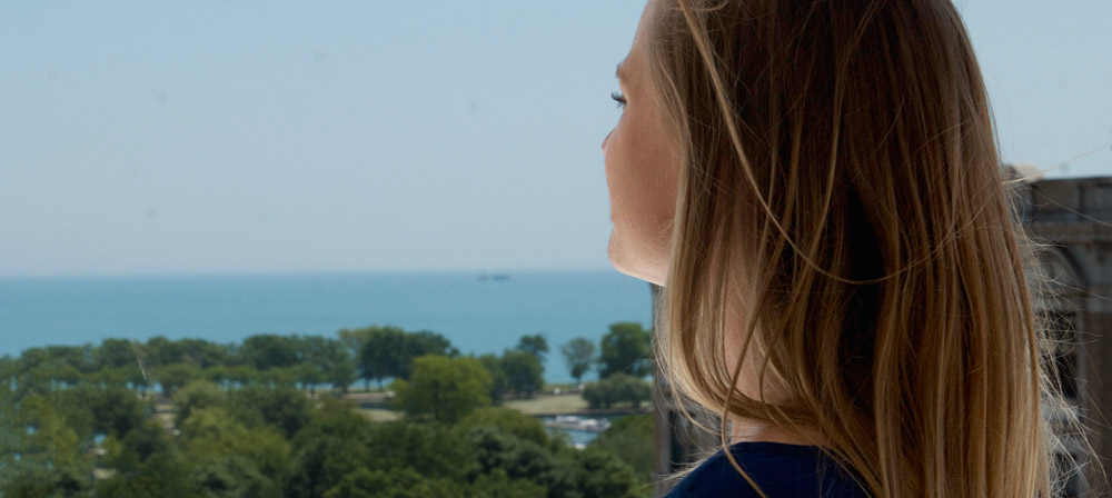 Woman taking in the view of Lincoln Park and Lake Michigan from the roofdeck
