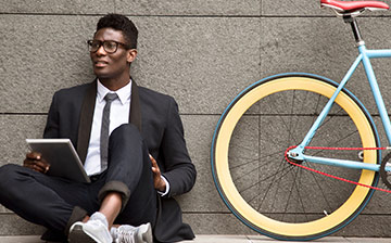 A well dressed man sitting next to a colorful bike